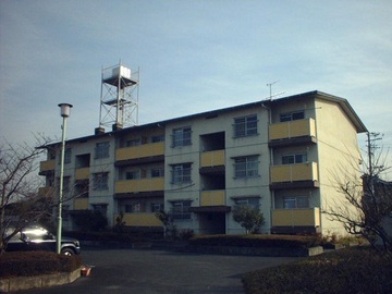 3階建ての集合住宅を駐車場側から見た写真