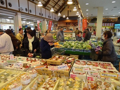 たくさんの果物や野菜が並べられた店内で、買い物をしている客