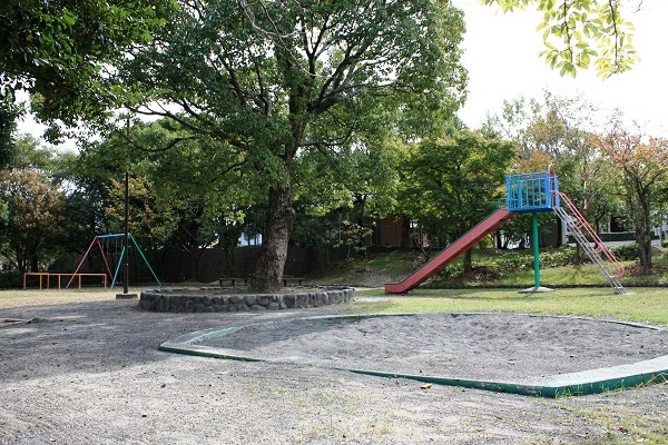 沢山の木々に囲まれた自然豊かな八幡公園。公園内にはブランコ、滑り台、砂場が設置されている