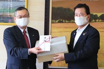 ブリヂストンエラステック株式会社代表取締役の荻島厚さんから松井市長へ目録が手渡される様子