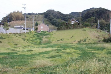 奥が小高い丘になった洋望台1号公園の写真、丘の上には家が見える