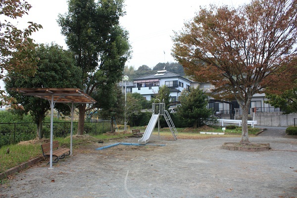 滑り台と砂場と、屋根付きベンチがある公園の画像。