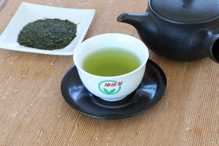 お茶が入った湯呑、急須と茶葉の画像