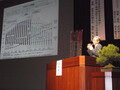 掛川市健康医療シンポジウム開催会場壇上でグラフを表示しながら講演を行っている篠原彰先生