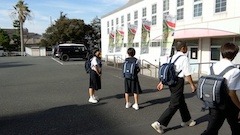 大浜中学校の学生が登校する奥で
風になびくのぼり旗の様子