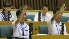 男子中学生、女子中学生が手を挙げている写真