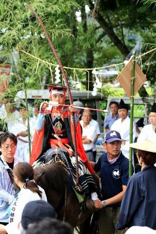 流鏑馬神事で騎乗から矢をつがえる子ども