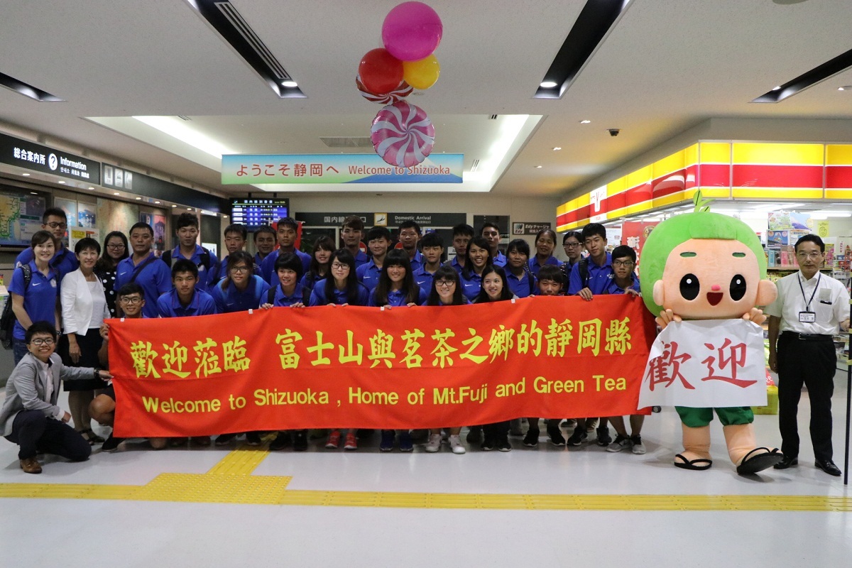 台湾アーチェリーチームを迎え、歓迎の幕を掲げ、集合写真を撮っている様子