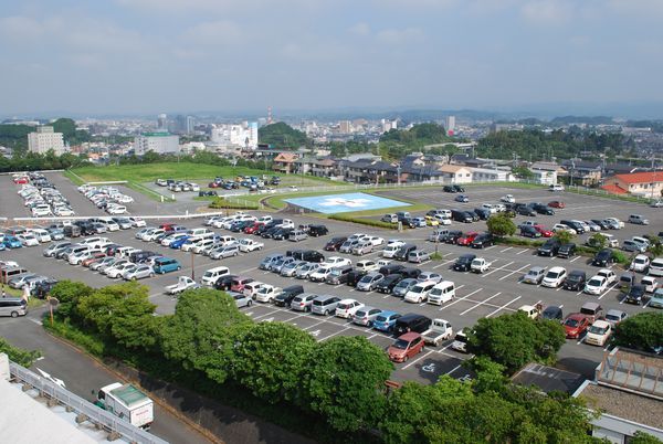 市立病院屋上からの眺め。手前に病院の駐車場、奥に市街地が見える。