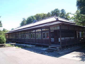 仰徳(こうとく)記念館の建物外観。平屋の建物で、屋根は瓦葺き。庭に面している戸の上半分が、すべてガラスになっている。