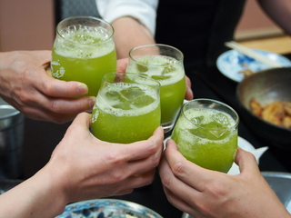 緑茶が入ったグラスで乾杯している手元の写真
